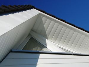 Pose de frisettes bois peintes en blanc pour l’habillage de la toiture d’une maison, France Rénovation Toiture