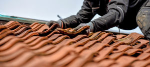 Remplacement de tuiles abîmées sur une toiture en rénovation, France Rénovation Toiture